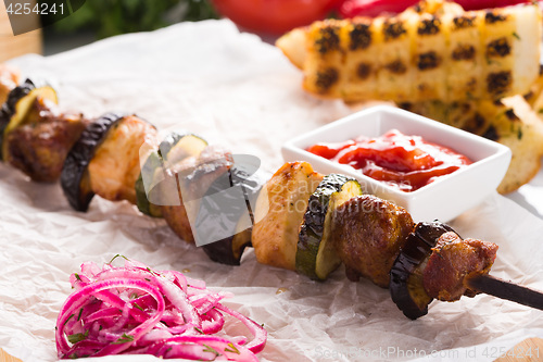 Image of shish kebab on skewers with onions and vegetables. 