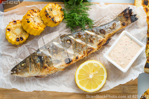 Image of fish baked on the grill. with potatoes and lemon. 