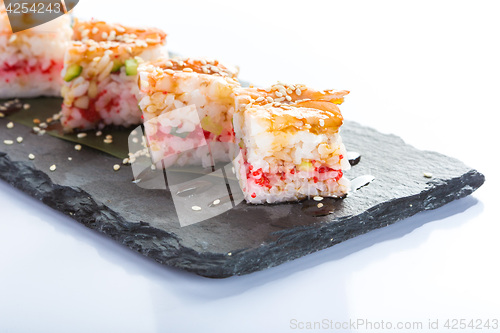 Image of set of sushi on a slate square plate. 