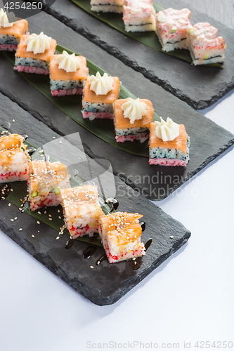 Image of set of sushi on a slate square plate. 