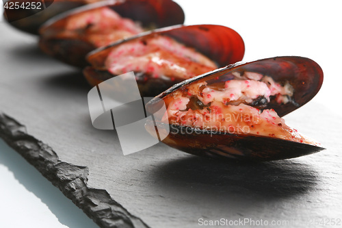 Image of mussels in their shell on a black slate plate