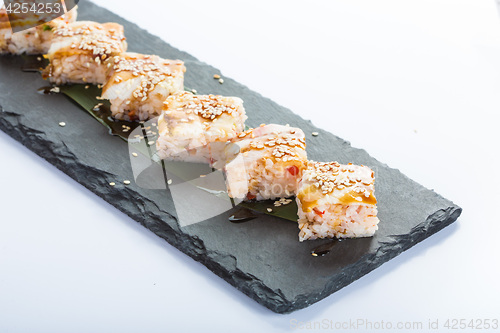 Image of set of sushi on a slate square plate. 