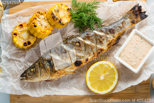 Image of fish baked on the grill. with potatoes and lemon. 