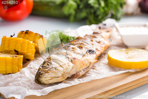 Image of fish baked on the grill. with potatoes and lemon. 