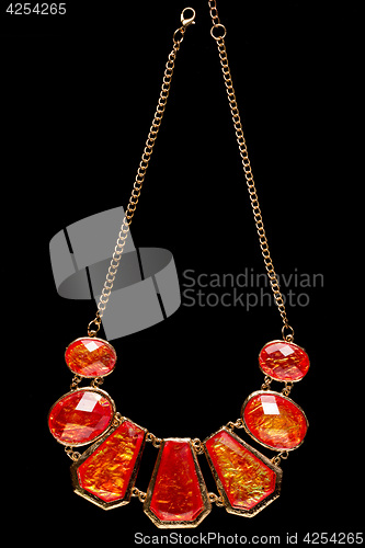 Image of red necklace on a black background. gems. 