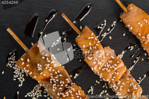 Image of fish kebabs. on a black slate plate.