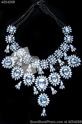 Image of blue necklace on a black background. gems. 