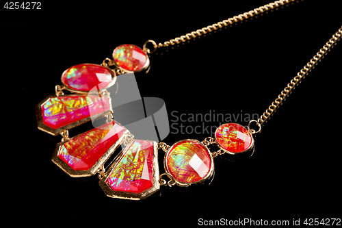 Image of red necklace on a black background. gems. 