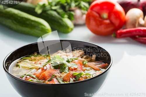 Image of tomato soup in a black plate. 