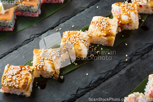 Image of set of sushi on a slate square plate. 