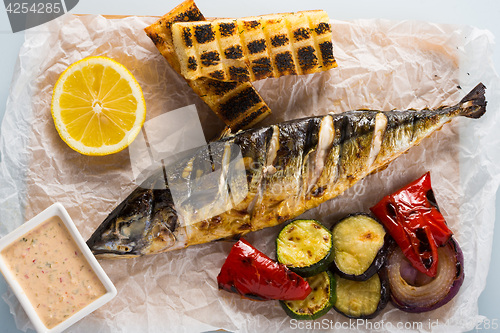 Image of fish baked on the grill. with potatoes and lemon. 