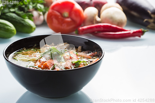 Image of tomato soup in a black plate. 