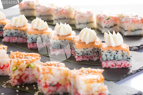 Image of set of sushi on a slate square plate. 