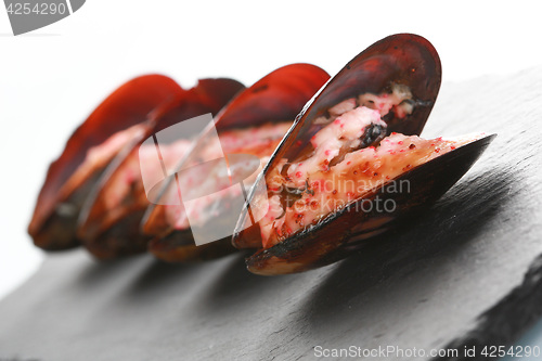 Image of mussels in their shell on a black slate plate