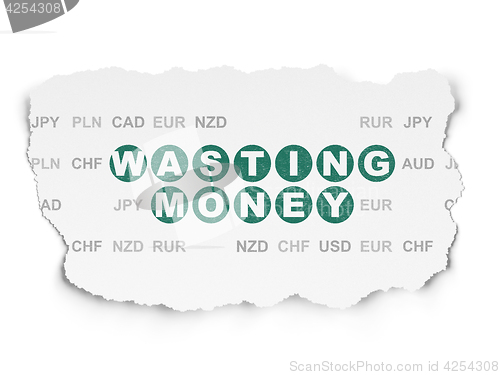 Image of Currency concept: Wasting Money on Torn Paper background