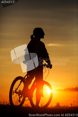 Image of Silhouette of a bike on sky background during sunset