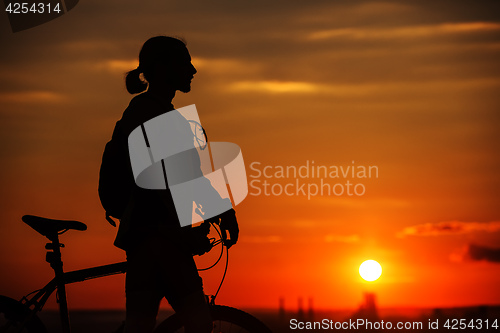 Image of Silhouette of a bike on sky background during sunset
