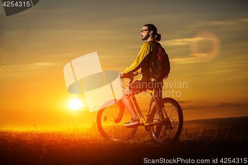 Image of Sporty Man Riding a Bicycle on the Country Road.