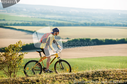 Image of Young man cycling on a rural road