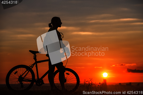 Image of Silhouette of a bike on sky background during sunset