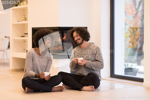 Image of multiethnic couple  in front of fireplace