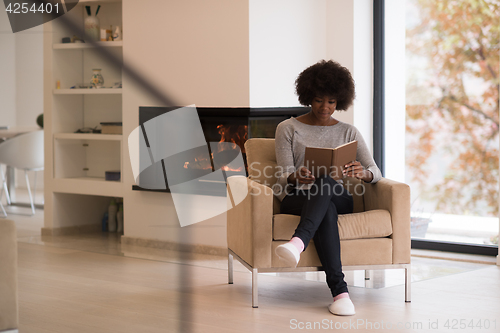 Image of black woman at home reading book