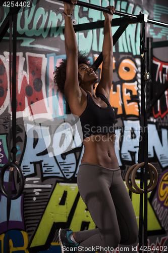 Image of black woman doing pull ups