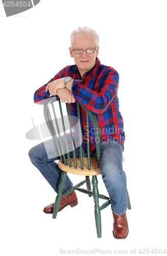 Image of A happy senior man sitting on chair.