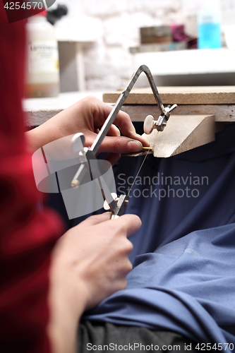 Image of Creating jewelry. Manually creating jewelry. Jeweler&#39;s workshop. Jeweler saws blade.