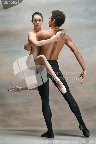 Image of Couple of ballet dancers posing over gray background