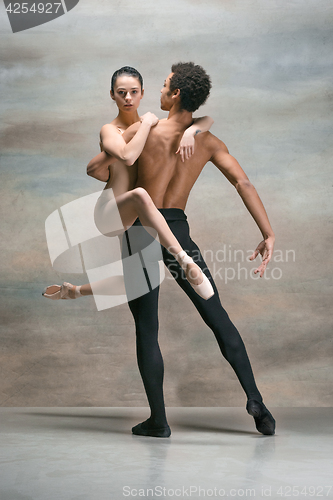 Image of Couple of ballet dancers posing over gray background