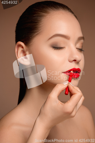 Image of Beautiful female lips with make-up and brush