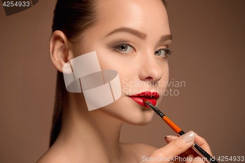 Image of Beautiful female lips with make-up and brush