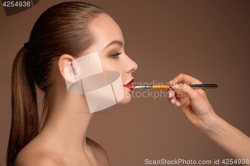 Image of Beautiful female lips with make-up and brush