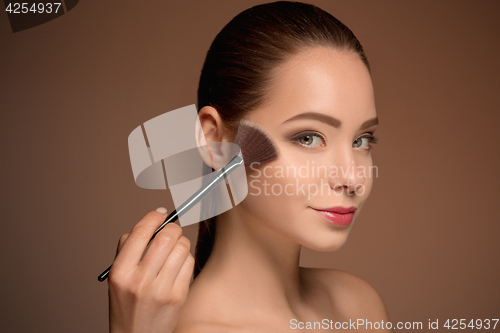 Image of Beauty Girl with Makeup Brush. Perfect Skin. Applying Makeup