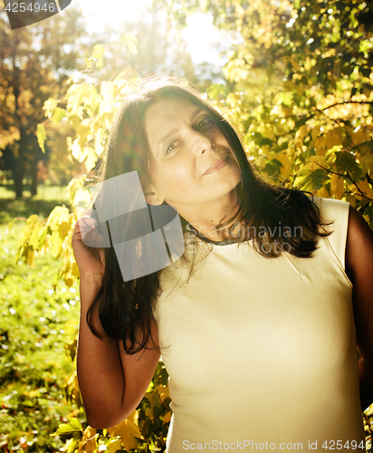 Image of mature real brunette woman in green spring park, lifestyle conce