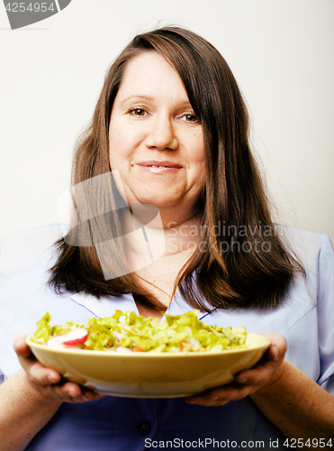 Image of fat white woman having choice between hamburger and salad close 