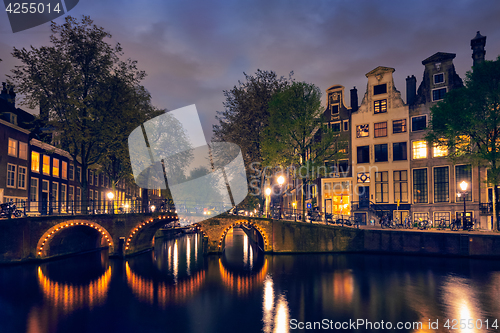 Image of Amterdam canal, bridge and medieval houses in the evening