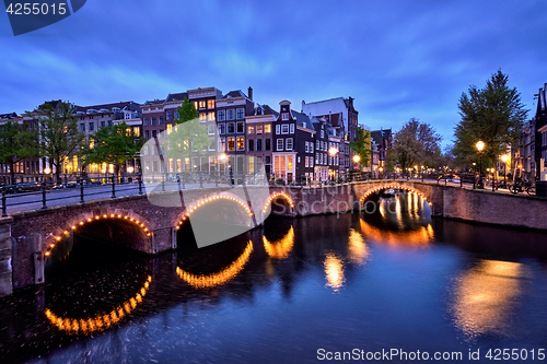 Image of Amterdam canal, bridge and medieval houses in the evening