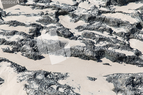 Image of close up of stone or volcanic rock with sand