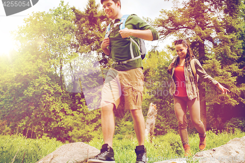 Image of happy couple with backpacks hiking outdoors