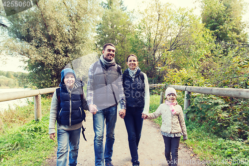 Image of happy family with backpacks hiking in woods