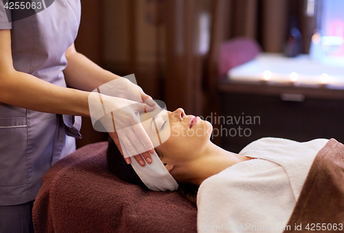 Image of woman having face and head massage at spa