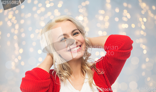 Image of happy smiling young woman in red cardigan