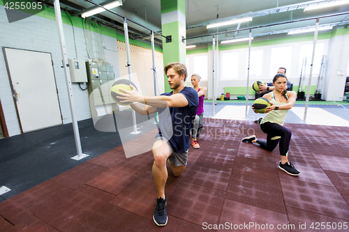 Image of group of people with medicine ball training in gym