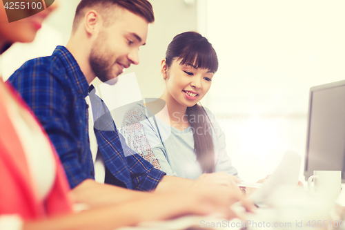 Image of happy creative team or students working at office