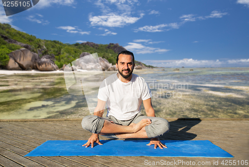 Image of man making yoga in scale pose outdoors