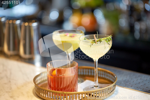 Image of tray with glasses of cocktails at bar