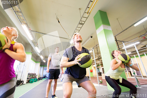 Image of group of people with medicine ball training in gym