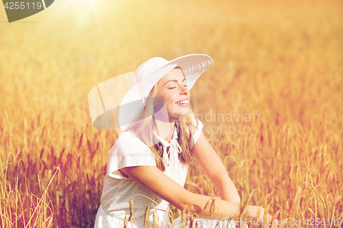 Image of happy young woman in sun hat on cereal field